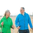 Lachendes älteres Paar beim Nordic Walking