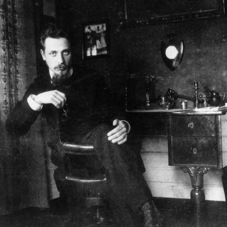 Der Dichter Rainer Maria Rilke sitzt in seinem Büro