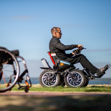 Mann fährt in einem geländegängigen Rollstuhl, daneben steht sein Alltagsrollstuhl: Raffinierte Technik eröffnet Behinderten neue Möglichkeiten der Mobilität. Der Funsport befeuert die Entwicklung.