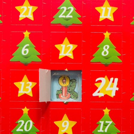 Ein roter Adventskalender mit Stern und Tannenmotiven. Das erste Türchen ist geöffnet. 