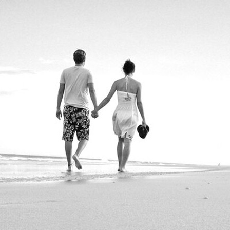 Ein Paar spaziert am Strand entlang.