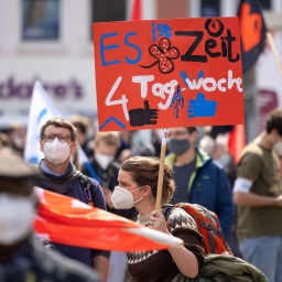 Eine Demonstrantin fordert bei einer DGB-Kundgebung zum 1. Mai auf dem Anger die Vier-Tage-Woche.