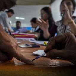 Ein Wahlhelfer markiert einen Finger mit unauslöschlicher Tinte, nachdem die Person Ihre Briefwahlstimme für die bevorstehenden Parlamentswahlen abgegeben hat. 