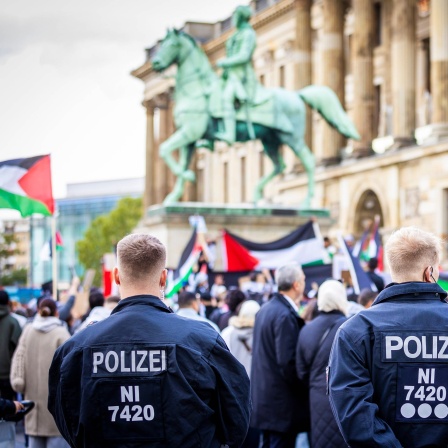 Polizisten beobachten Demonstranten, die an einer pro-palästinensischen Demonstration auf dem Braunschweiger Schlossplatz teilnehmen. Nach dem Terrorangriff der Hamas auf Israel kam es deutschlandweit zu zahlreichen Reaktionen.
