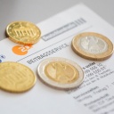 Geldmünzen liegen auf einem Schreiben zum Beitragsservice.