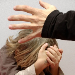 Symbolbild: Ein Kind hält sich die Hände über den Kopf, um sich vor den Schlägen eines Erwachsenen zu schützen.