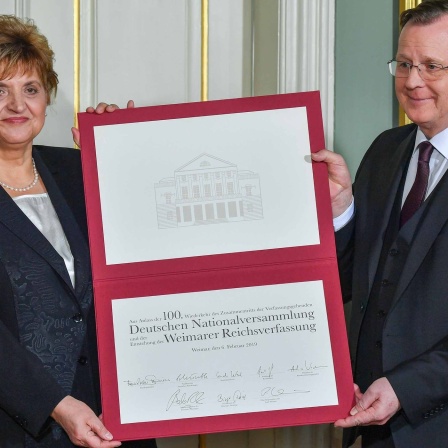 Bodo Ramelow und Birgit Diezel zeigen das "Gedenkblatt" zum Festakt 100 Jahre Weimarer Verfassung
