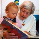 Eine ältere Frau liest einem kleinen Kind eine Geschichte vor