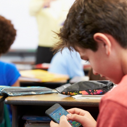Schüler spielt auf Smartphone