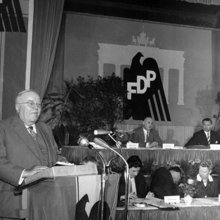 Der FDP-Bundesvorsitzende Dr. Reinhold Maier am Rednerpult während seines Grundsatzreferates, rechts dahinter der FDP-Vorstand 1959.