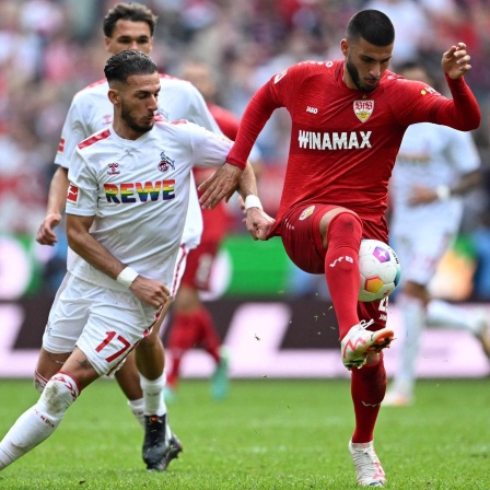 Deniz Undav vom VfB Stuttgart im Duell mit Kölns Leart Paqarada