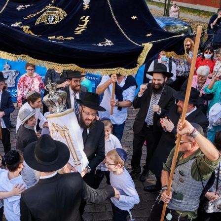 Rabbiner Yehuda Teichtal (Mitte) hält die neuen Thora in der Hand. Kinder mit Kippas tanzen um ihn herum. Viele Rabbiner aus anderen Gemeinden kamen nach Potsdam, um mit den Gemeindemitgliedern die Einweihung der neuen Thora für die Synagoge in der Kiet