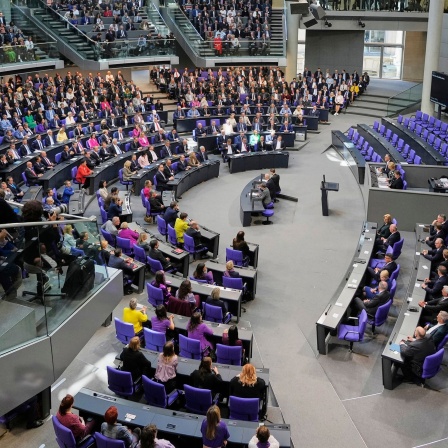 Abgeordnete warten im Bundestag in Berlin auf den Beginn einer Sitzung, in der Friedrich Merz zum neuen Bundeskanzler gewählt werden soll.