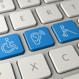 Computertastatur mit drei weißen Grafiken auf blauem Grund: ein Rollstuhl, eine Person mit Langstock, und einem Symbol für Schwerhörigkeit