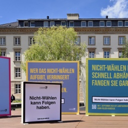 Plakate einer Kampagne zur Wahlmobilisierung. Auf dem Vordersten steht im Stil des Warnhinweises auf einer Zigarettenschachtel: "Nicht-Wählen kann Folgen haben."