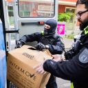 Polizisten laden bei einer Hausdurchsuchung in Berlin-Kreuzberg einen Karton in ein Fahrzeug. Polizei und Staatsanwaltschaft haben im Zuge eines Ermittlungsverfahrens zu Mitgliedern der Letzten Generation 15 Objekte in sieben Bundesländern durchsucht.