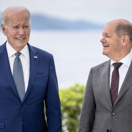 Der US-Präsident Joe Biden und der deutsche Bundeskanzler Olaf Scholz stehen im Freien nebeneinander.