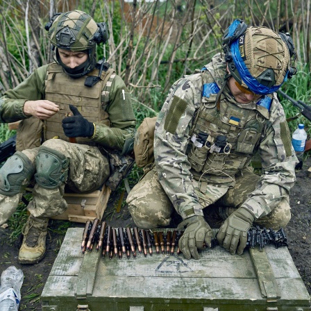 Zwei ukrainische Soldaten bereiten ihre Munition vor.