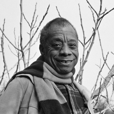 Schwarz-Weiß-Porträt von Schriftsteller James Baldwin vor Bäumen in Saint Paul de Vence an der Côte d'Azur.