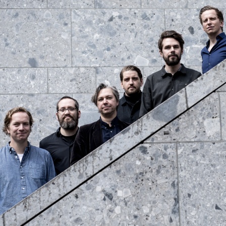 Die sechs Jazzmusiker und Mitglieder des Kölner Jazzkollektivs stehen für ein Pressebild auf einer Treppe.
