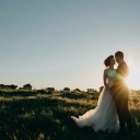 Eine Braut und ein Bräutigam umarmen sich im Sonnenuntergang.