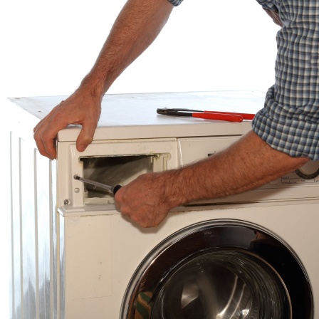 Arbeiter repariert eine Waschmaschine