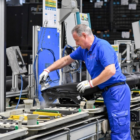 Arbeiter fertigen im Autozulieferunternehmen Lear Corporation GmbH Autositze.