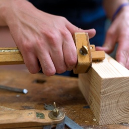 Ein Tischler misst Holz aus (Bild: picture alliance / imageBROKER / Rolf Fischer)