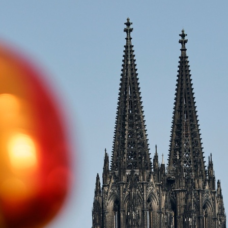 Ein Ballon in Regenbogenfarben neben dem Kölner Dom beim Christopher Street Day 2023 in Köln