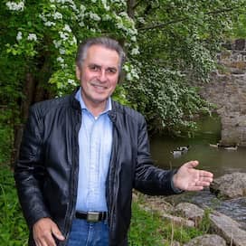 Naturschützer Claus-Peter Hutter zeigt mit der Hand auf einem Bach mit einer Steinbrücke.