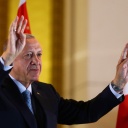 Amtsinhaber Recep Tayyip Erdogan winkt nach dem Sieg in der Stichwahl um das Präsidentenamt in der Türkei vor einer türkischen Fahne in Richtung seiner Anhängerinnen und Anhänger.