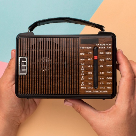 Ein kleines Retro-Radio in der Hand einer Person