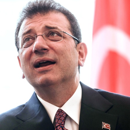 Der Oberbürgermeister von Istanbul, Ekrem Imamoglu, steht vor einer türkischen Fahne.