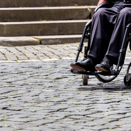 Eine Person sitzt in einem Rollstuhl