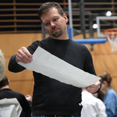 Wahlhelfer bei der Auszählung der Stimmzettel nach der Teilwiederholung der Bundestagswahl in Berlin