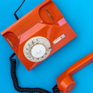 Orangefarbenes Telefon mit Wählscheibe