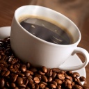 Kaffeetasse mit schwarzem Kaffee und Kaffeebohnen