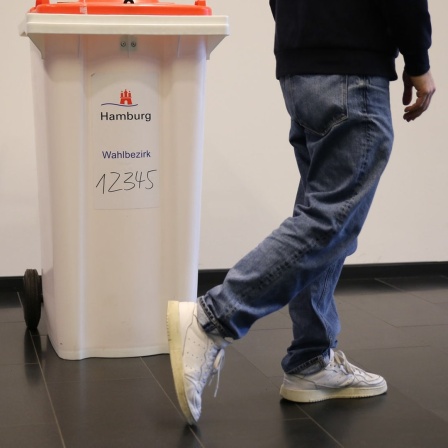 Eine Person geht an an einer Wahlurne in einem Hamburger Wahllokal vorbei. (Archivfoto)