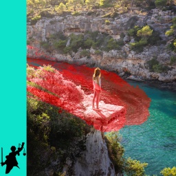 eine leichtbekleidete Frau steht oberhalb einer malerischen Bucht auf Mallorca