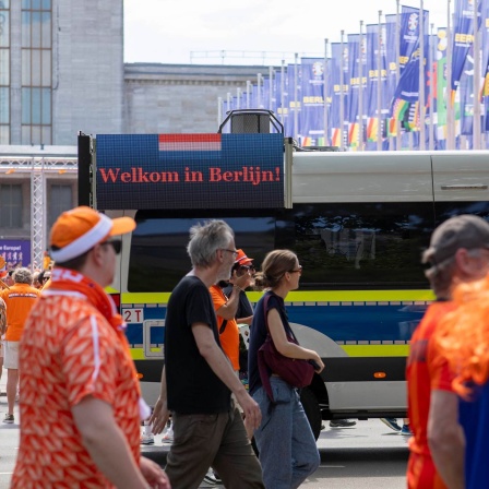 Niederländische Fans ziehen durch Berlin, auf einem Polizeiwagen steht "Welkom in Berlijn".