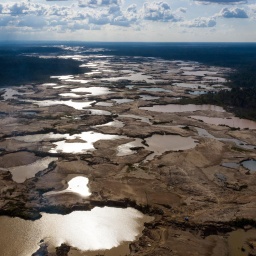 Luftaufnahme einer großen Fläche aus Schlamm, die sich im Amazonasregenwald ausbreitet.