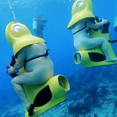Zwei nackte Menschen unter Wasser auf einer Unterwasser-Scooter