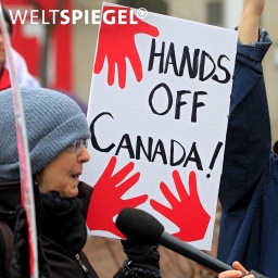 Frau mit Protestschild auf dem steht: Hands off Canada!