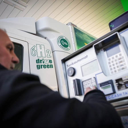 Ein Mann tankt einen Wasserstofflastwagen an einer Tankstelle