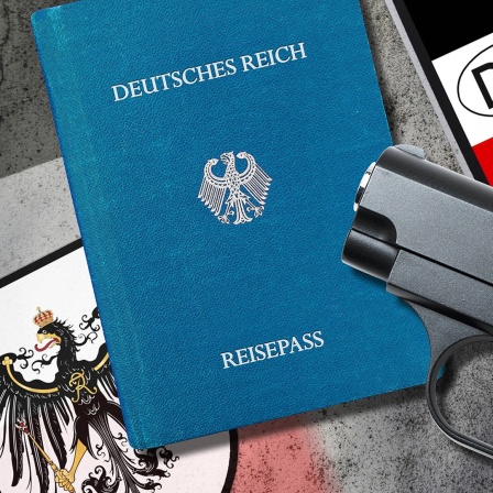 Ein Reichsbürger-Pass liegt neben einer Waffe und einem Nummernschild.