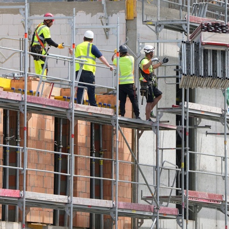 Vier Arbeiter stehen auf dem Baugerüst der Baustelle am Alten Markt in der Potsdamer Innenstadt.