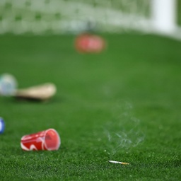 Auf dem leeren Rasen vor einem Tor liegt Abfall, den Stadionbesucher auf das Spielfeld geworfen haben