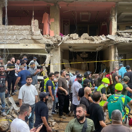 Menschen versammeln sich am Ort eines israelischen Raketeneinschlags in den südlichen Vororten von Beirut.
