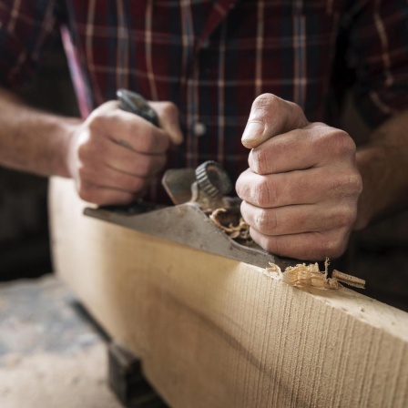 Mann arbeitet in einer Holzwerkstatt.