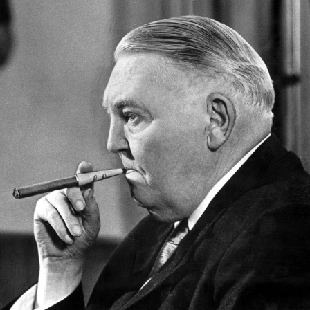 Porträtfoto von Ludwig Erhard im Profil mit einer Zigarre im Mund.